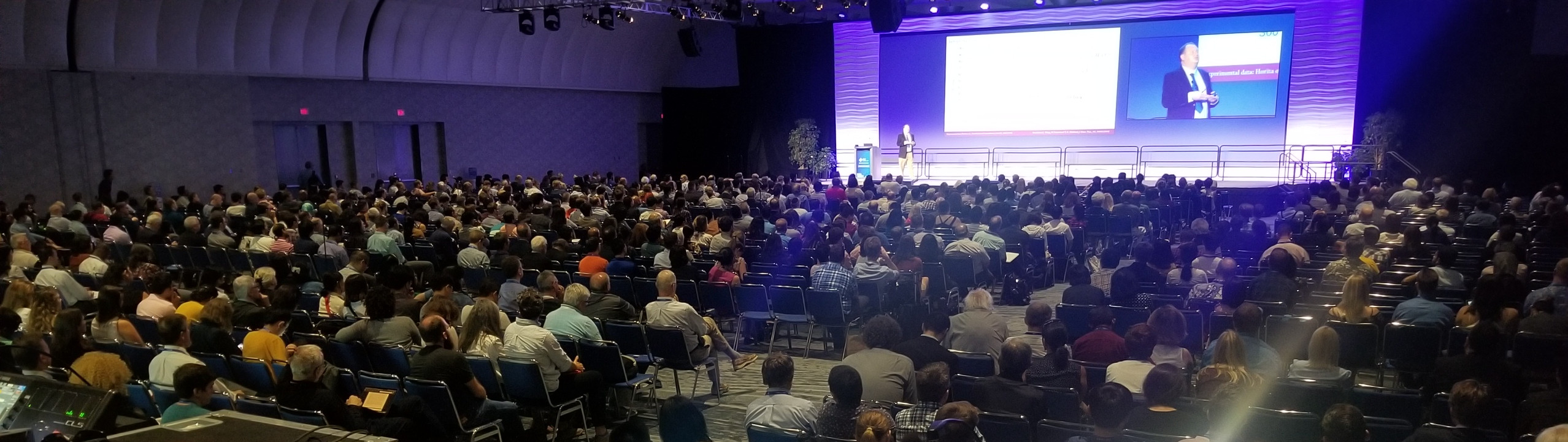 Photo of Tom giving a lecture in front of a large room of people