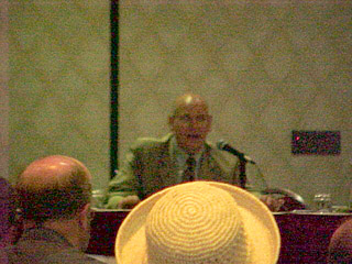 Simon Margolis speaks over the hat of Katya Hill at the Town Hall Meeting