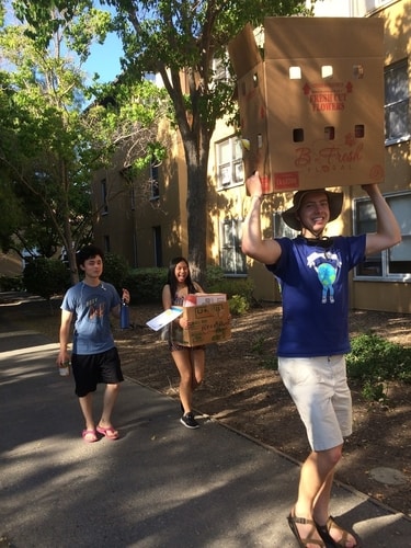 Student volunteers carrying cardboard boxes