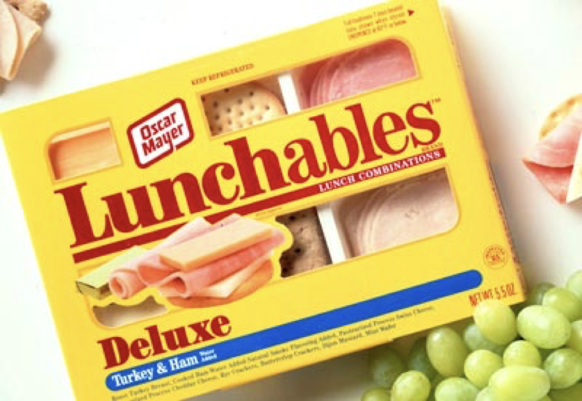 An image of a 'Lunchable' which contains lunch food, including meat, crackers, cheese, dessert, etc.