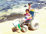 Jessa at he beach in a beach wheelchair