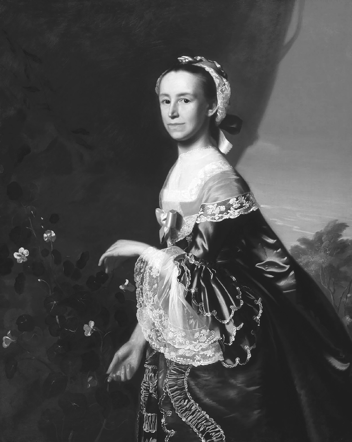 A painting by John Singleton Copley of Mercy Otis Warren, who is looking directly at the audience. She is wearing a royal blue low-necked gown with white trimming. Her hair is pulled back and covered by black and white ribbons. On the left side of the painting is a plant that is blooming flowers. In the background on the right side of the painting, behind Mercy, is a tree and a blue sky.