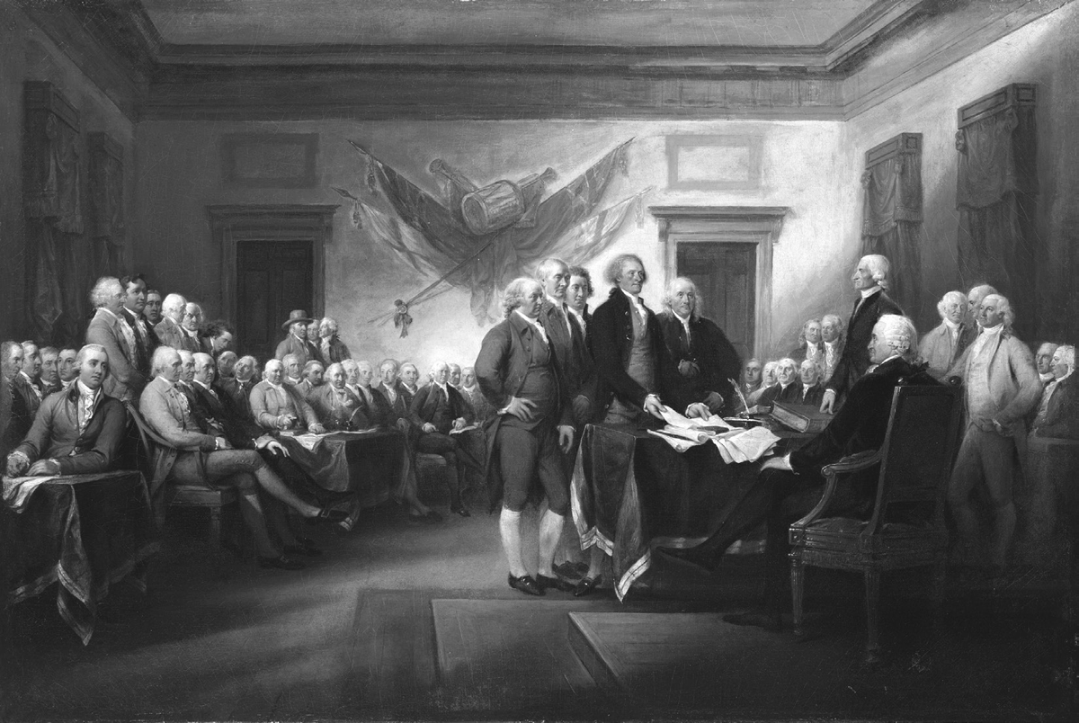 In this oil painting by John Trumbull titled The Declaration of Independence, July 4, 1776, five drafters of the Declaration of Independence present the document to four two other members of the Second Continental Congress inside the main chamber of Independence Hall. John Adams, Roger Sherman, Robert Livingston, Thomas Jefferson, and Benjamin Franklin stand in the center of the painting placing the draft of the Declaration of Independence on a desk in front of John Hancock, who is seated at the desk, and Charles Thomas, who is standing to Hancock’s right. The room is filled with 35 additional signers of the Declaration of Independence—some standing, some seated—looking on at the action in the center of the painting. In the background, four different British flags are mounted on the wall directly above the drafters’ heads.