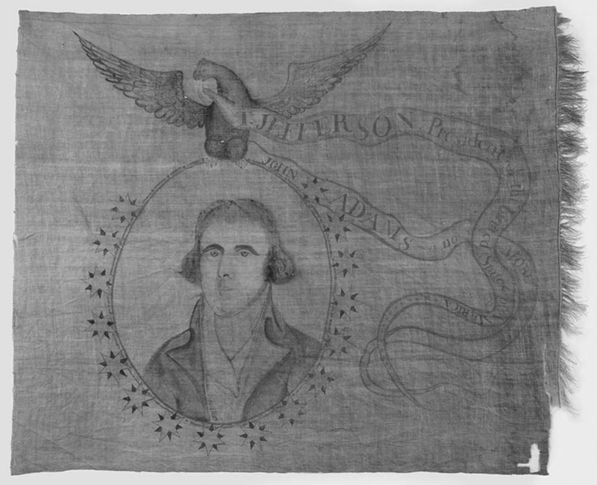 This stitched victory banner celebrating the presidential election of Thomas Jefferson depicts a portrait of Jefferson in the center of a red circle that is outlined by yellow and blue stars. An eagle sits atop the circle with a ribbon in its mouth that reads, â€œT. Jefferson, President of the United States of America. John Adams is no more.â€