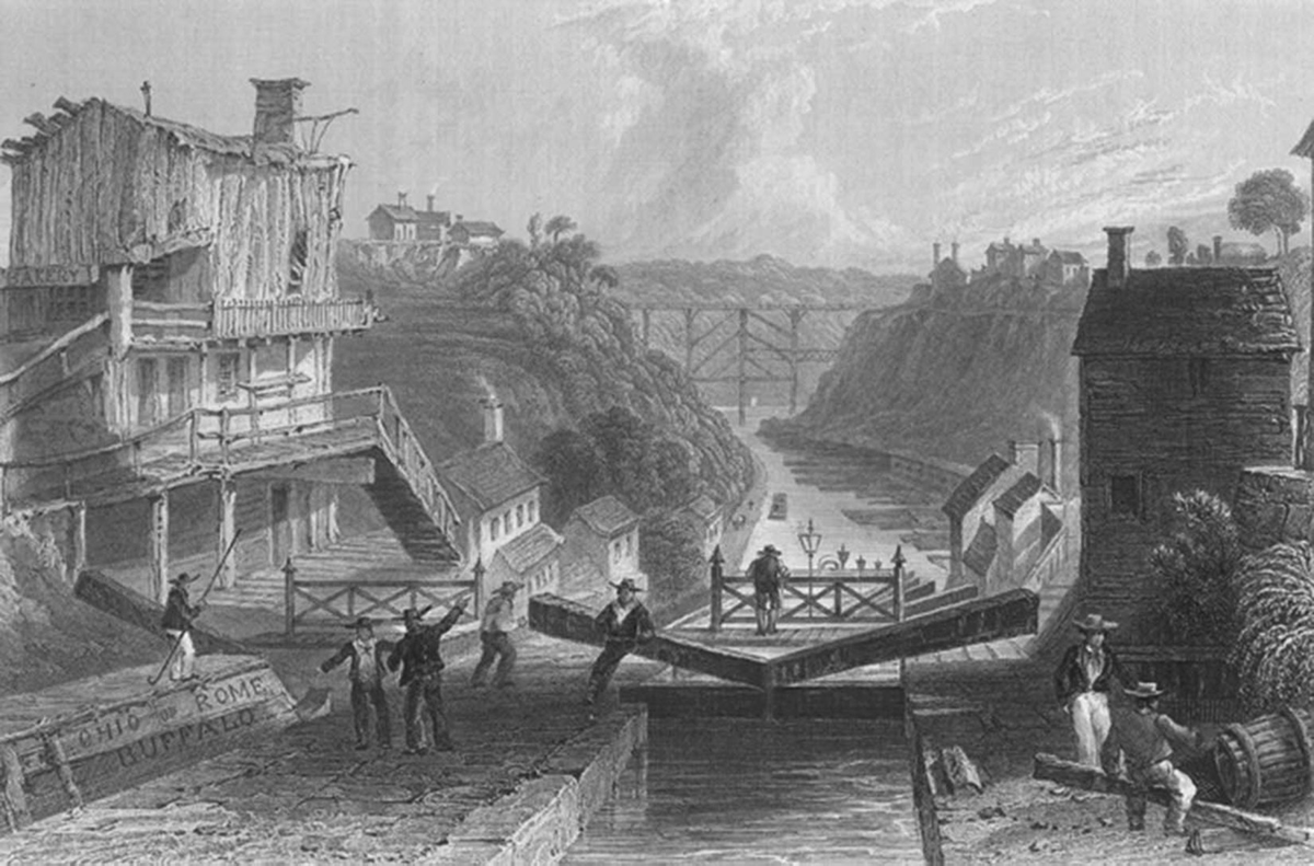This 1839 engraving depicts the Erie Canal as it runs through a town in Ohio. The canal runs through the center of the artwork as buildings from the town run along the land on either side of it. Across the foreground of the painting, men are seen in conversation, preforming a series of labor tasks, and viewing the canal from a bridge. The canal is cutting through what looks like a canyon. In the background, a train track bridge connects the ridges of the canyon high above the canal, which curves its way through the canyon.