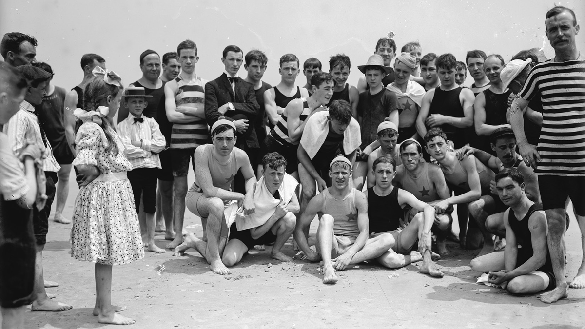 Young men pose on a beach.