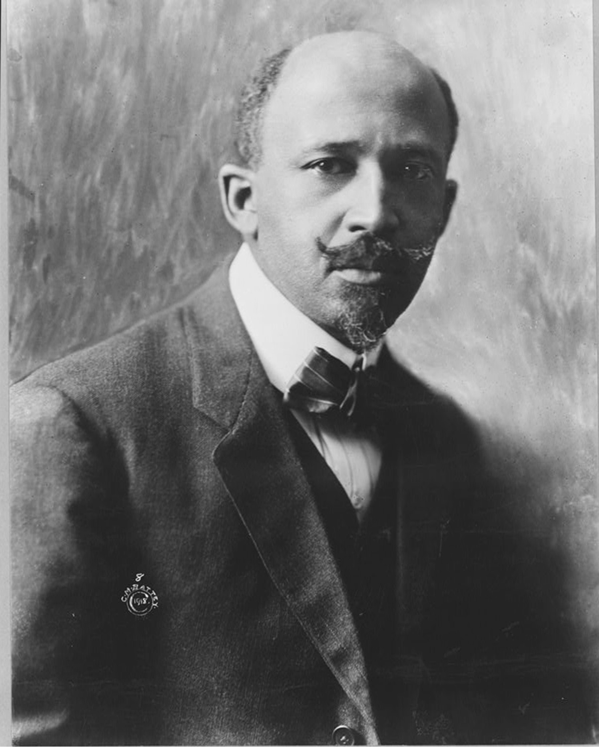 A man in a suit looks at the camera.