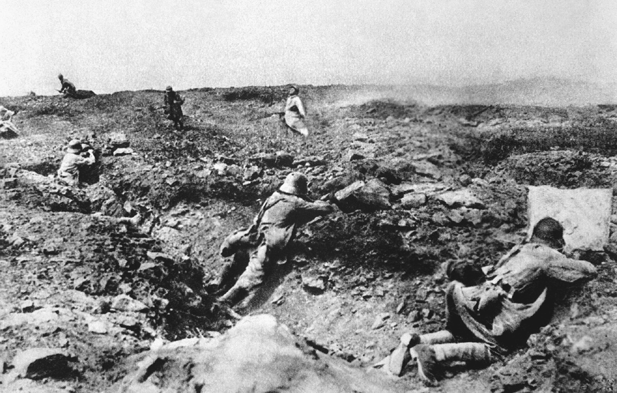 Soldiers in a denuded landscape fire on enemy soldiers.