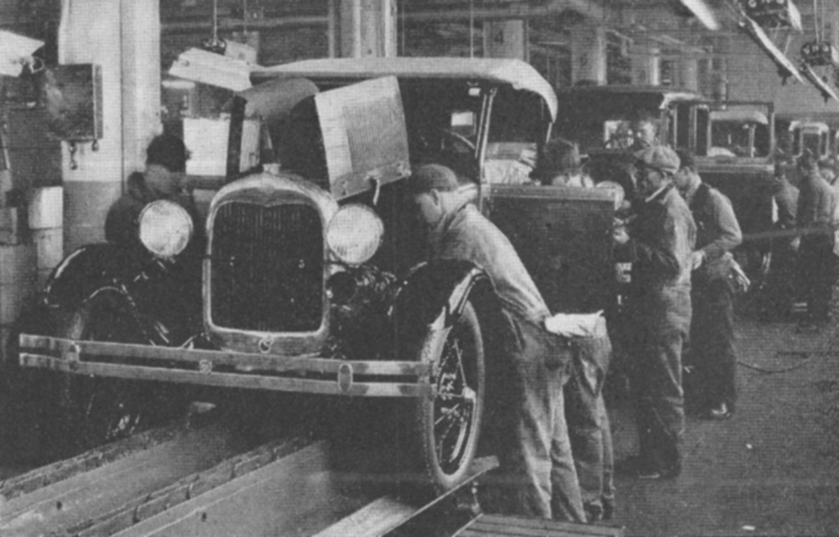 Men work on an automobile assembly line.