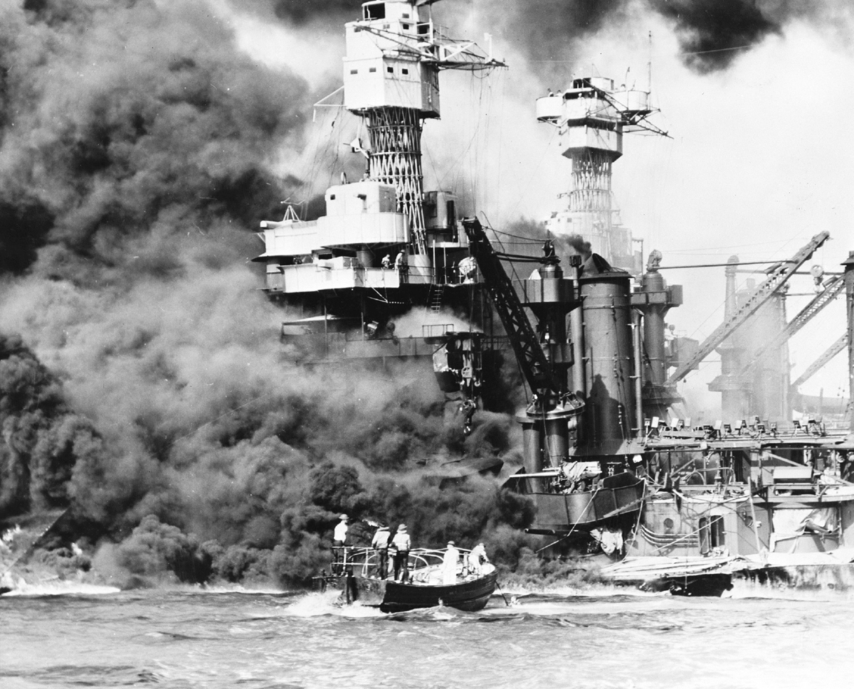 A large military ship burns.