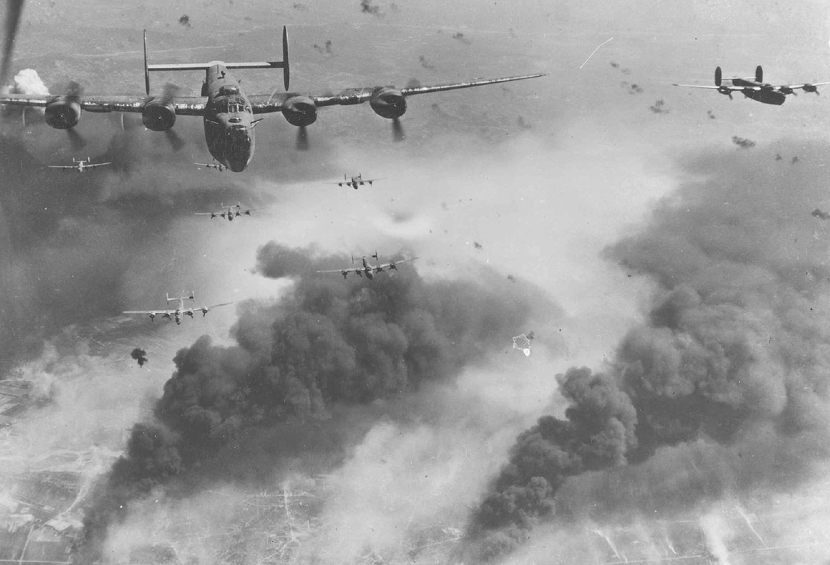 Bombers fly over a smoke-filled city.