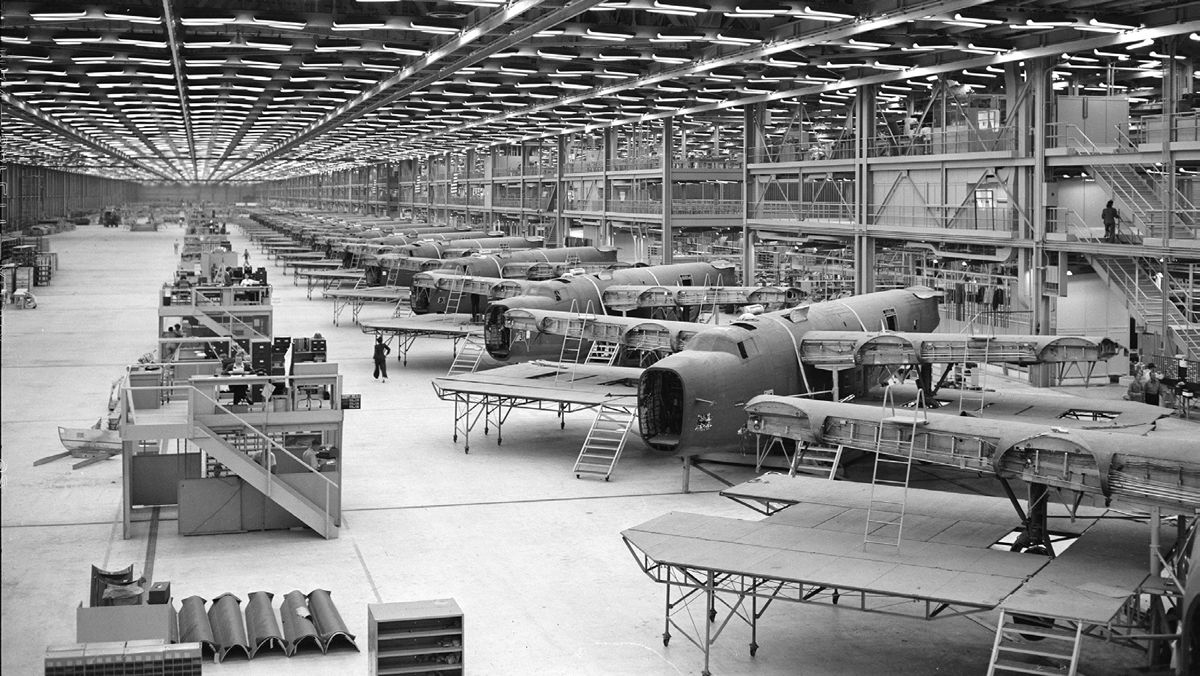A sprawling factory with rows of airplanes being assembled.