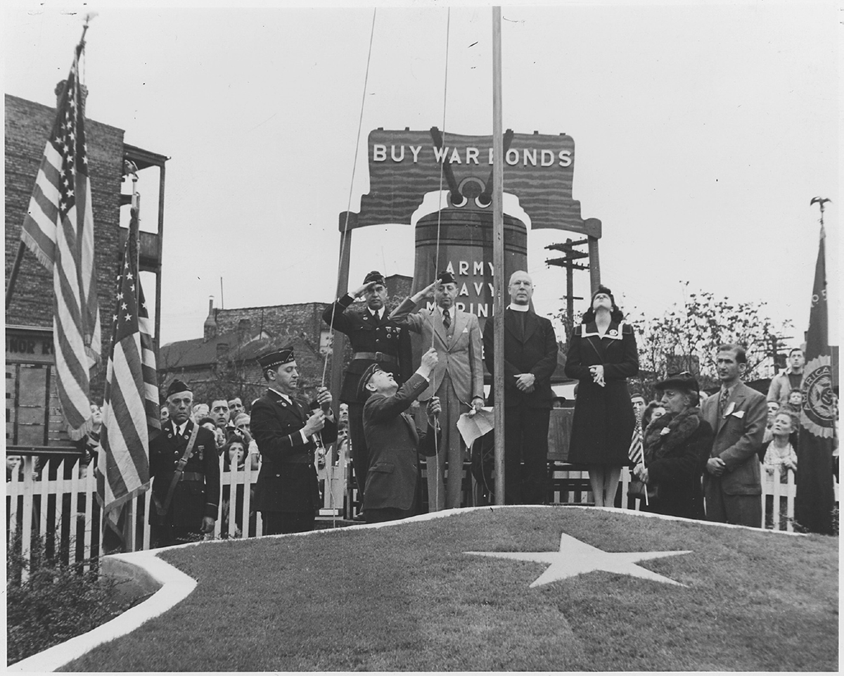 A crowd watches as a flag is raised.