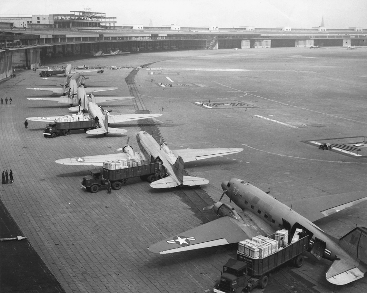 A row of military aircraft outside of an airport.