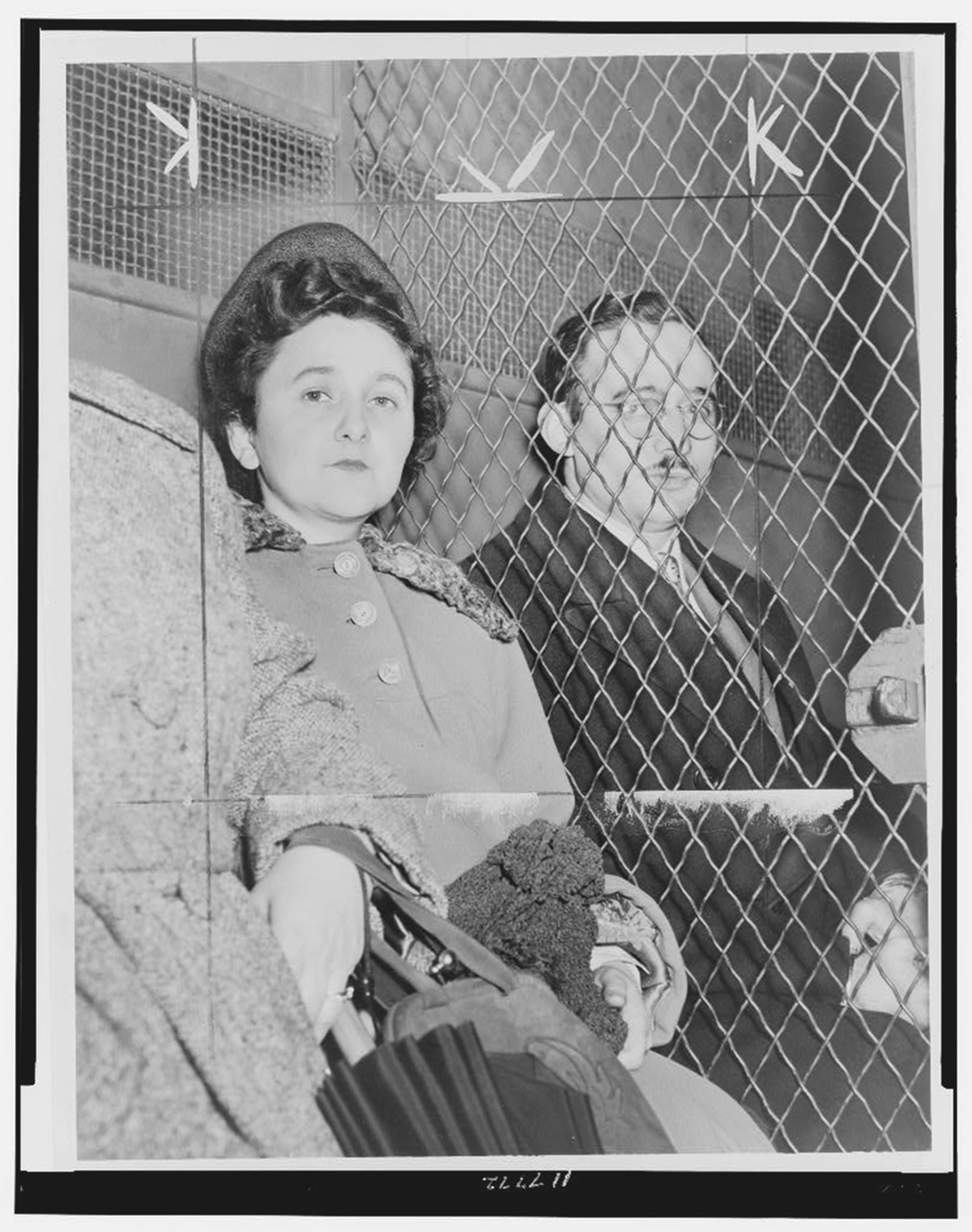 A man and woman sit, separated by a gate.