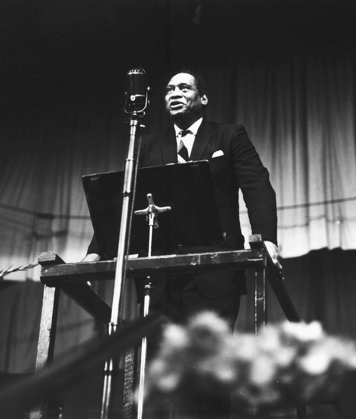 A man stands before a microphone.