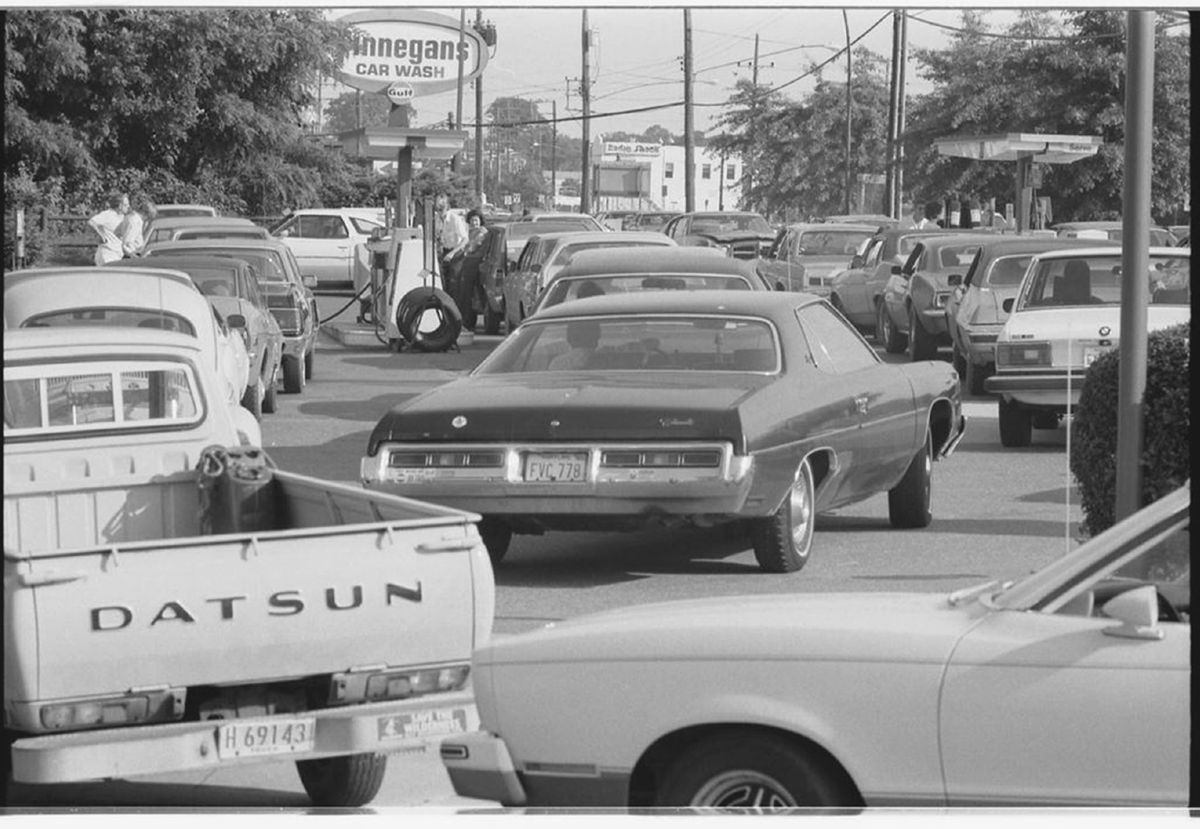 A line of cars outside of a gas station.