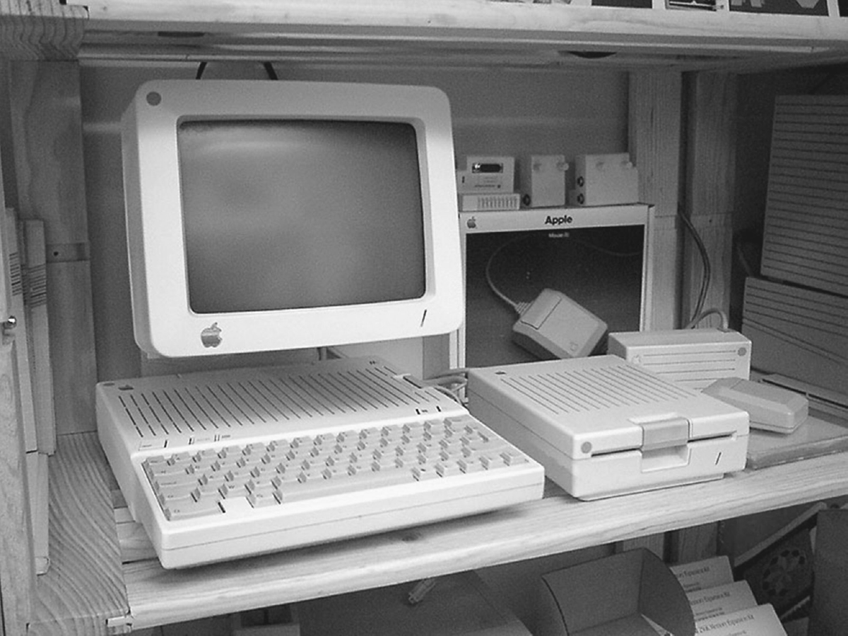 An Apple computer and accessories rest on a shelf.