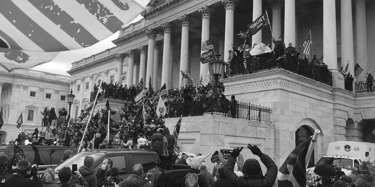 A jubilant crowd stands around the U.S. Capitol Building.