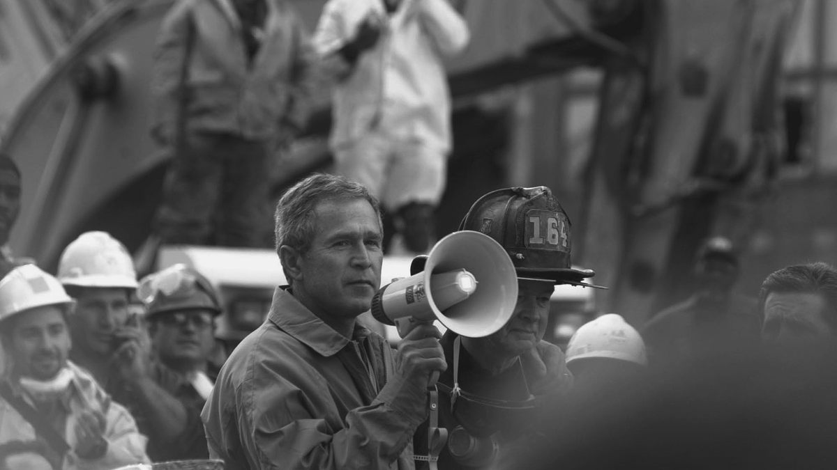 A man holding a bullhorn looks out at a group of rescue workers.