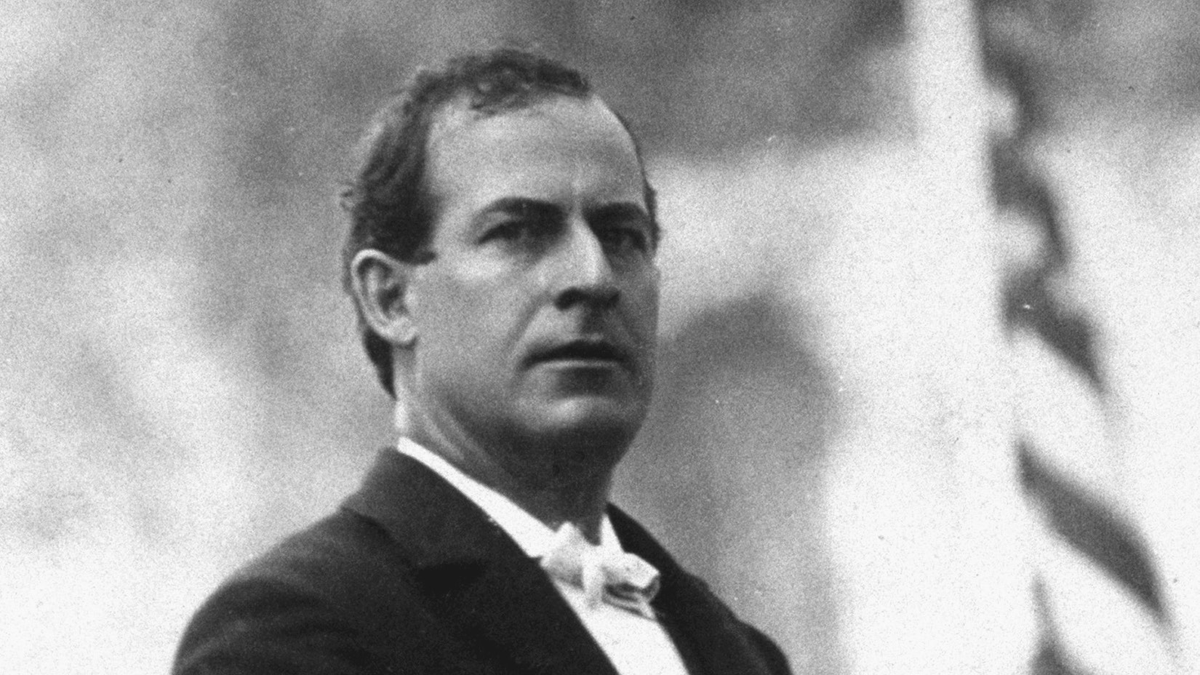 A man in a suit stares into the distance.