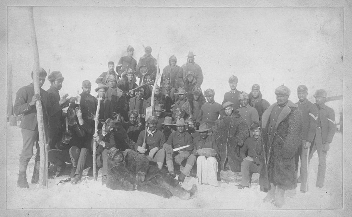 A group picture of Black soldiers, many clothed in buffalo robes.