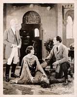 George Arliss and David Powell watach as  Harry T. Morey lies on the floor with Alice Joyce kneeling beside him
